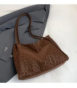 Close-up of leopard print tote bag fabric and shoulder strap on a grey suit jacket