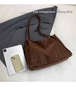 Leopard print tote bag size comparison with smartphone and tablet on blazer