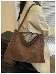 Deep brown leopard print tote bag styled with a beige trench coat for a minimalist look