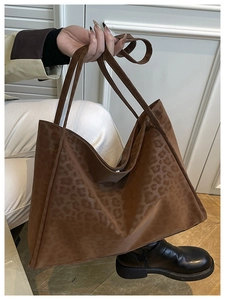 Macro detail of large brown leopard print tote bag with magnetic closure and slim straps