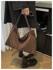 Detail of a brown leopard print tote bag with soft suede texture and stylish shoulder strap