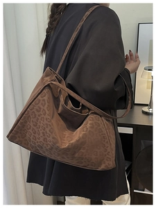 Detailed view of leopard print tote bag with soft suede texture on a model's shoulder