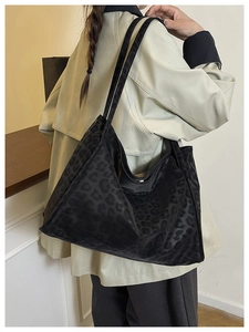 Close-up of the black leopard print tote bag texture and large shoulder strap detail