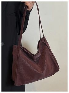 Detail of dark brown leopard pattern tote bag with dual straps worn over the shoulder