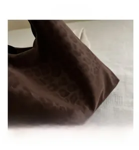 Close-up of matte brown leopard print texture on a large fashion tote bag detail