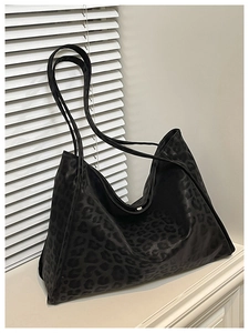 Detail of large black leopard print tote bag featuring metallic magnetic closure