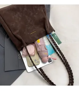 Detail of spacious dark brown suede tote bag interior with braided shoulder straps