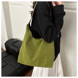 Detailed shoulder view of the lime green leopard print tote bag on a model in a modern room