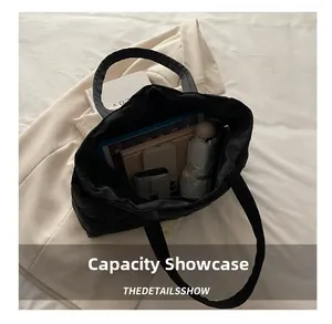 Spacious interior of black quilted tote bag showing tablet, umbrella, and daily items