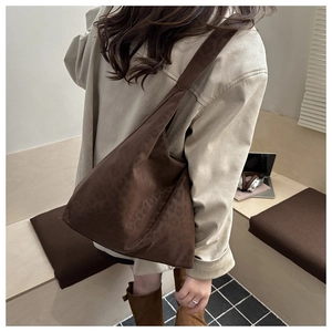 Detailed close-up of brown leopard print tote bag in soft suede texture with wide strap