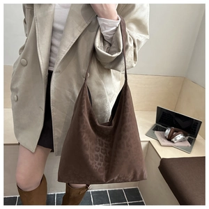 Detailed view of leopard print tote bag with soft suede texture in a stylish office setting