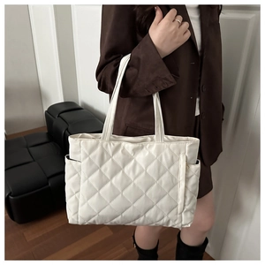 Side view of white quilted tote bag featuring functional pockets and spacious design
