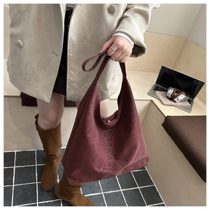 Close-up of leopard print burgundy suede tote bag showing magnetic clasp and texture