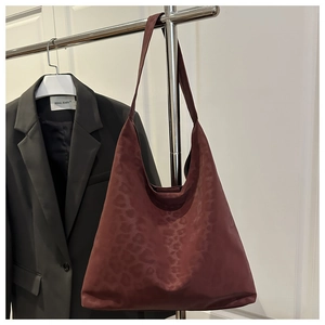 Detail of burgundy leopard print tote bag with soft texture and wide shoulder strap