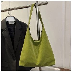 Close-up of green leopard print suede tote bag with textured finish and integrated handle