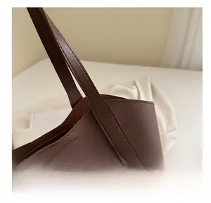 Detail der verstärkten Nähte und Lederstruktur an einer dunkelbraunen Tote-Schultertasche