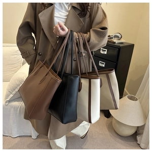 Detail view of four large minimalist tote bags in black, brown, white, and apricot colors
