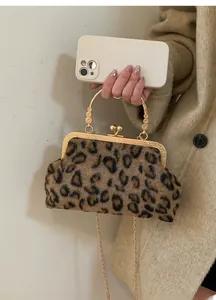 Detailed view of leopard print handbag with golden metal frame and chain strap accessory
