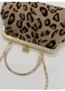 Detail of leopard print handbag featuring gold engraved metal frame and floral handle decor