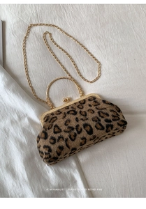 Detail of retro leopard print clutch bag with gold metal frame and ball clasp closure
