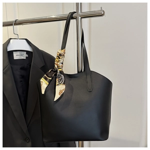 Detail der schwarzen Leder-Einkaufstasche mit bedrucktem Seidenschal am Griff für das Büro