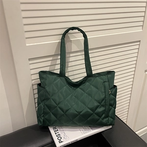 Quilted tote bag in dark green with diamond stitching and large capacity for daily commute