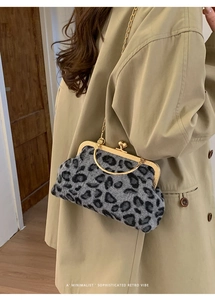 Detail of grey leopard faux fur texture with vintage gold frame and chain strap