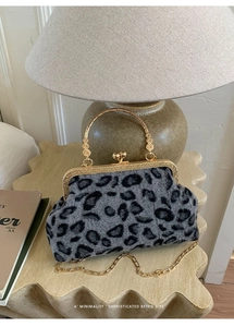 Macro detail of leopard print faux fur bag with golden frame and metal ring handle