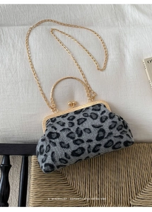 Detailed view of leopard print retro handbag with gold metal clasp and chain strap