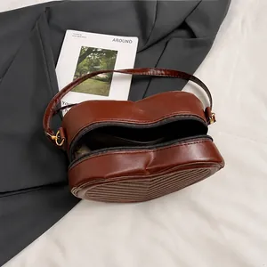 Internal view of brown heart-shaped quilted shoulder bag showing interior space