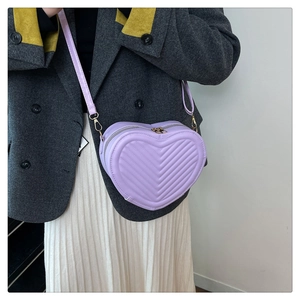 Detailed view of a purple heart-shaped crossbody bag with elegant V-shaped quilting texture