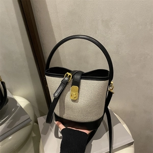 Retro contrast bucket bag in beige woven fabric and black leather with gold clasp