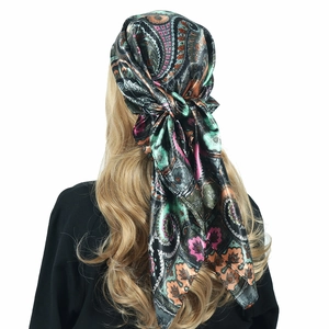 Detail of bohemian paisley print satin scarf worn as a headscarf with silky texture