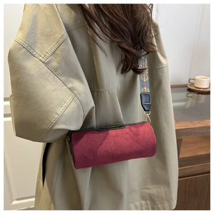 Detail of burgundy frosted cylinder bag with bohemian wide embroidered strap