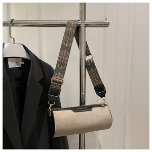 Detail of cylinder bag with patterned wide strap and FASHION & BAGS lettering