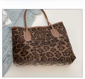 Detail der weichen Leopard-Tasche aus Stoff mit hochwertigem braunem Ledergriff