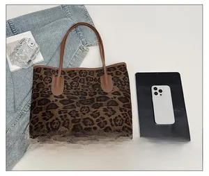 Detailansicht der Leopard-Tragetasche mit braunen Ledergriffen und Innendetails