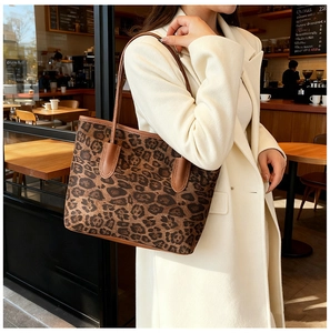 Detail der Leopard-Tasche mit braunen Lederriemen getragen mit weißem Wintermantel