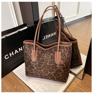 Detailansicht der Leopard-Tragetasche mit braunen Ledergriffen und robuster Textur