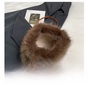 Top-down detail showing the spacious interior and soft plush faux fur of the brown bucket bag