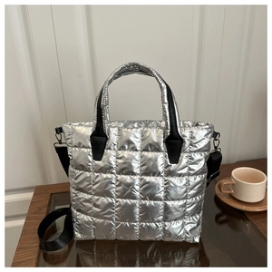 Detail of silver quilted tote bag showing metallic nylon texture and detachable strap