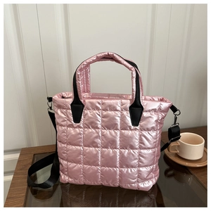 Detail of metallic pink quilted tote bag with silver hardware and black straps