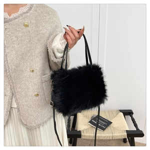 Detail of a fluffy black faux fur handbag with gold hardware and adjustable strap