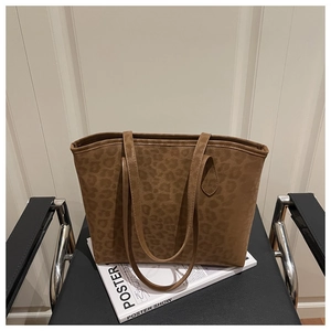 Détail de la texture et des anses du sac cabas léopard sur fond de studio minimaliste
