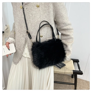 Detail of fluffy faux fur handbag featuring slender leather handles and elegant texture