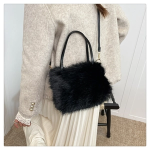 Detail of plush faux fur handbag with leather handle and golden metal buckle strap