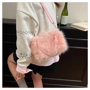 Detail of pink faux fur shoulder bag with soft plush texture and golden buckle strap