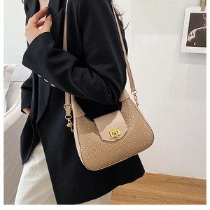 Detail of beige woven texture shoulder bag with elegant golden metal twist-lock clasp