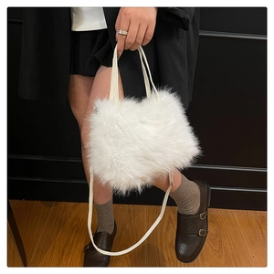 Detailed view of white faux fur handbag with a plush texture and slim shoulder strap