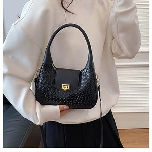 Detail of woven texture black hobo bag with gold metal buckle and round top handle